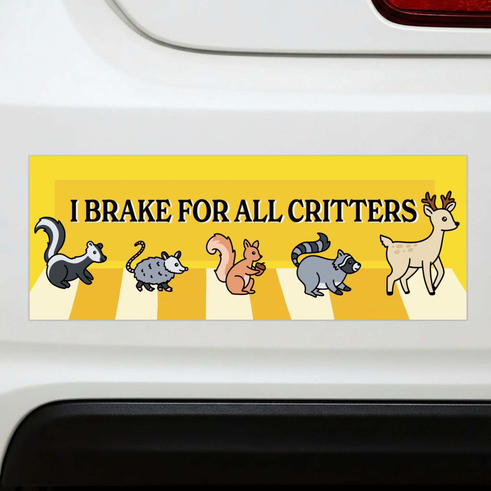 Sleazy Greetings funny bumper magnet displayed on the back of a white car featuring the phrase ‘I Brake For All Critters’ in bold black typography on a bright yellow background with cute illustrated woodland animals crossing a crosswalk, including a skunk, opossum, squirrel, raccoon, and deer. Humorous novelty car magnet with wholesome animal-lover humor and playful illustrated design shown in real-life automotive use.