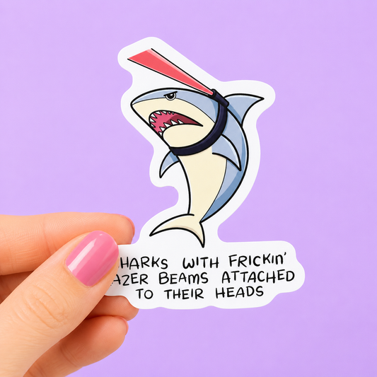 Sleazy Greetings funny die-cut vinyl sticker featuring an angry shark with a laser beam strapped to its head beside the phrase ‘Sharks With Frickin’ Lazer Beams Attached to Their Heads.’ Absurd meme-inspired sticker with chaotic villain energy, retro internet humor, and ridiculous action-movie vibes.