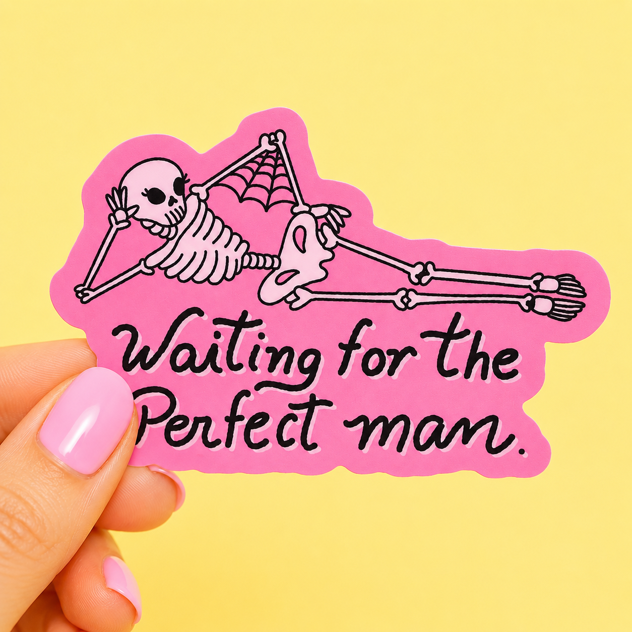 Sleazy Greetings funny die-cut vinyl sticker featuring a lounging cartoon skeleton with the phrase ‘Waiting for the Perfect Man.’ Pink sarcastic sticker with spooky cute artwork, dating humor, and playful gothic aesthetic.