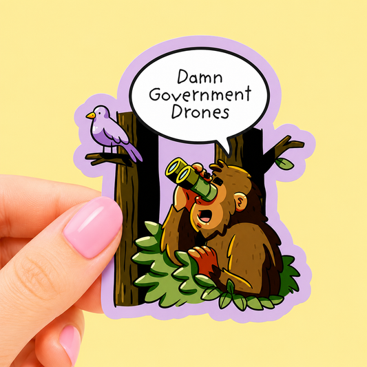 Sleazy Greetings funny die-cut vinyl sticker featuring a paranoid cartoon Bigfoot using binoculars while spotting birds and saying ‘Damn Government Drones.’ Conspiracy theory cryptid sticker with playful forest artwork, absurd humor, and chaotic meme aesthetic.