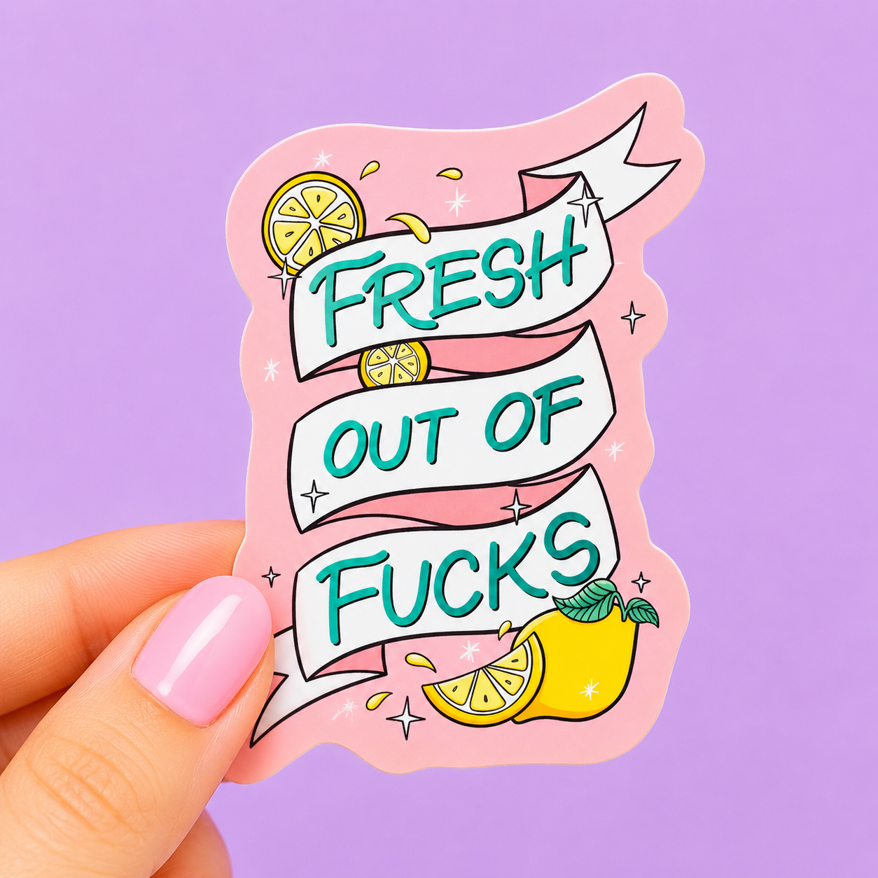 Sleazy Greetings funny vinyl sticker featuring the phrase ‘Fresh Out Of Fucks’ on a decorative ribbon banner with lemon illustrations and sparkly accents. Die-cut sarcastic sticker with pastel pink background, bold teal lettering, and playful trendy aesthetic.