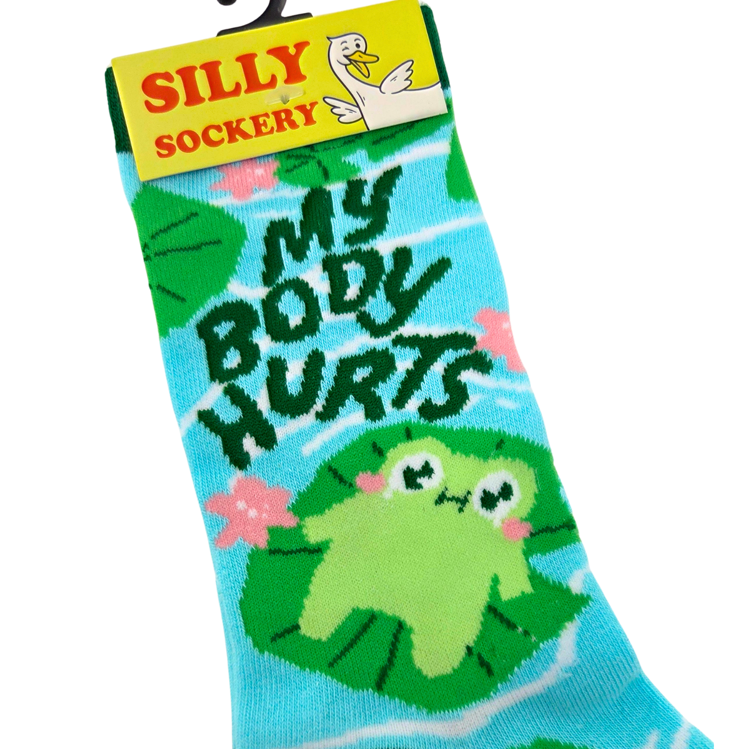 Sleazy Greetings novelty crew socks featuring a cute floating frog illustration with the phrase ‘No Body Hurries’ surrounded by lily pads, flowers, and pond-inspired patterns in bright aqua and green colors. Funny relaxing-themed crew socks with whimsical nature artwork and cozy laid-back humor.