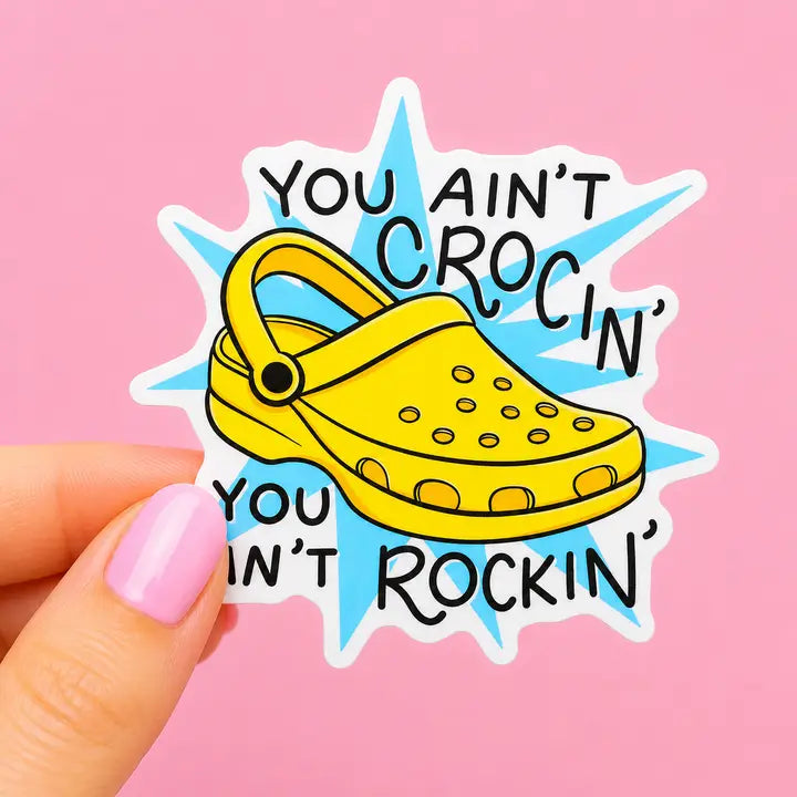 Sleazy Greetings funny Crocs vinyl sticker reading "You Ain't Crocin' You Ain't Rockin'" featuring a yellow clog illustration on waterproof die cut vinyl