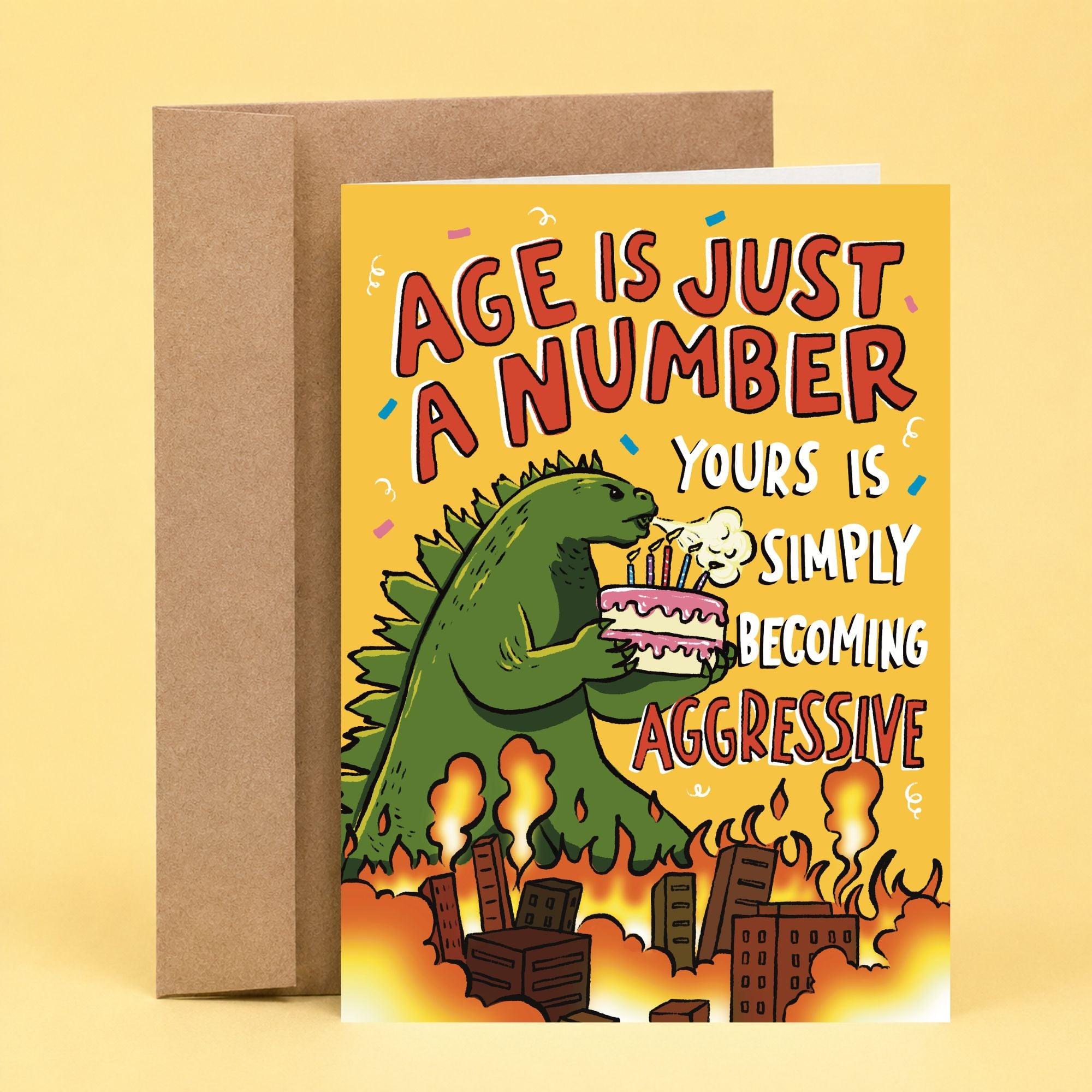Sleazy Greetings funny birthday card featuring a Godzilla-style monster holding a birthday cake above a burning city, with the phrase, “Age Is Just a Number, Yours Is Simply Becoming Aggressive.” Hilarious aging humor card for friends, family, and anyone getting older.