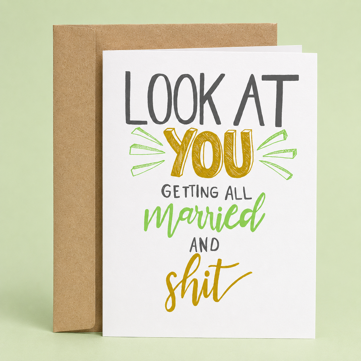 Sleazy Greetings funny wedding card featuring playful hand-lettered typography on a clean white background. The card reads, “Look At You Getting All Married and Shit,” offering a sarcastic and lighthearted way to celebrate an engagement, wedding, or newlywed couple. Displayed with a kraft envelope, this humorous wedding congratulations card is perfect for friends, siblings, coworkers, brides, grooms, and couples with a sense of humor.