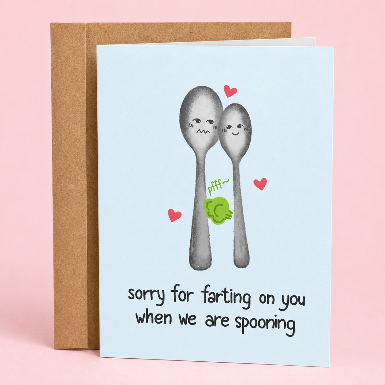 Sleazy Greetings funny love greeting card featuring two illustrated spoons cuddling with hearts and a cartoon fart cloud, with the humorous message “Sorry for Farting on You When We Are Spooning,” displayed with a kraft envelope for an anniversary, Valentine’s Day, or romantic gag gift card.