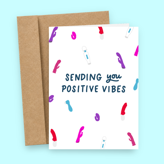 Sleazy Greetings funny encouragement greeting card featuring colorful vibrator and adult toy illustrations scattered across a white background with the cheeky message “Sending You Positive Vibes,” displayed with a kraft envelope for a humorous get well card, breakup gift, friendship card, or adult novelty greeting card.