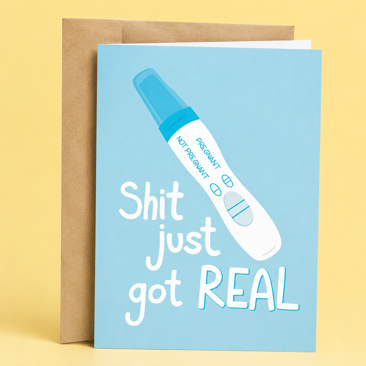 Sleazy Greetings funny pregnancy announcement card featuring a positive pregnancy test on a light blue background with the message “Shit Just Got Real.” The humorous card is designed for sharing pregnancy news and is displayed with a kraft envelope.