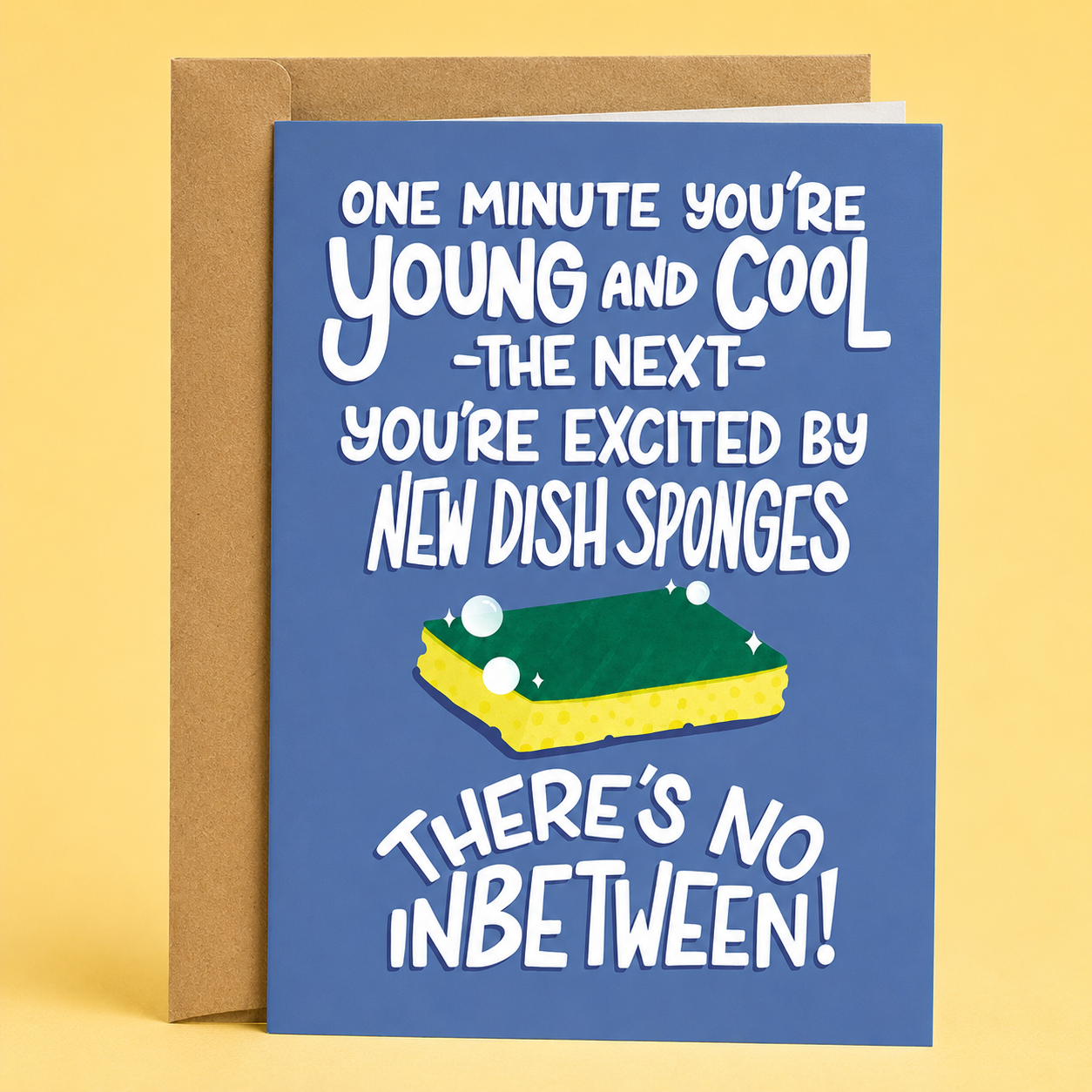 Sleazy Greetings funny birthday card featuring a sparkling new kitchen sponge on a blue background, with the relatable aging joke “One Minute You’re Young and Cool, The Next You’re Excited by New Dish Sponges. There’s No Inbetween!” paired with a kraft envelope.