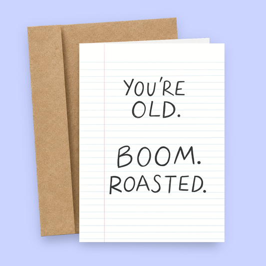 Sleazy Greetings funny birthday card designed like a sheet of lined notebook paper with the blunt joke “You’re Old. Boom. Roasted.” in handwritten-style text, paired with a kraft envelope.
