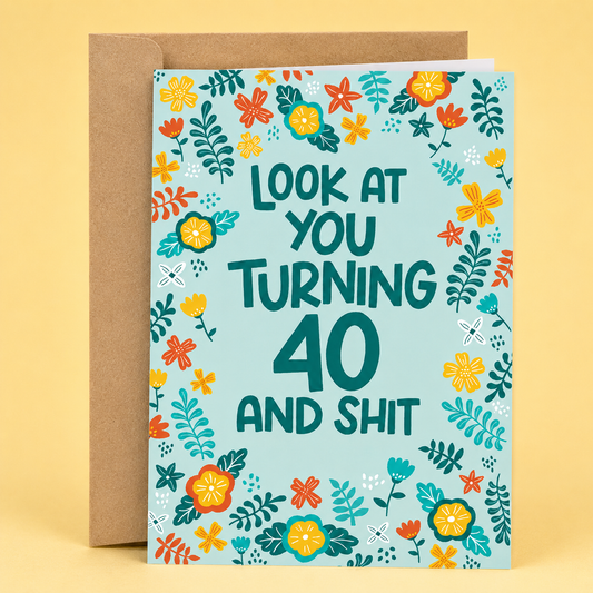 Sleazy Greetings funny 40th birthday card featuring a colorful floral border on a teal background, with the cheeky message “Look At You Turning 40 And Shit,” paired with a kraft envelope.