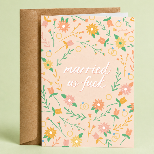 Sleazy Greetings funny wedding and marriage card featuring a soft floral pattern with flowers, greenery, and wedding rings on a blush beige background, with the cheeky message “Married As Fuck,” paired with a kraft envelope.