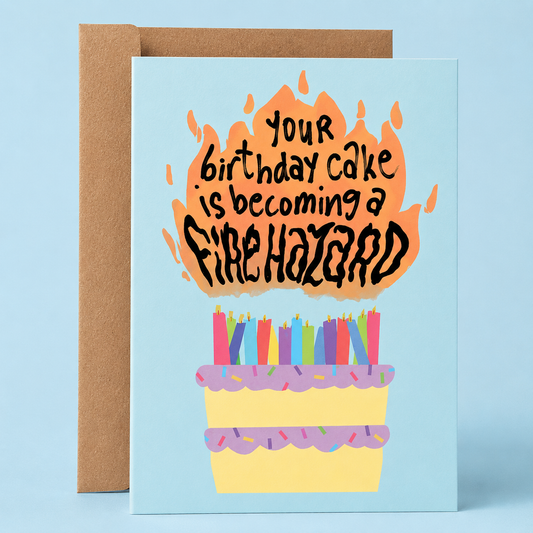 Sleazy Greetings funny birthday greeting card featuring a birthday cake covered in candles and flames on a light blue background with the joke “Your Birthday Cake Is Becoming A Fire Hazard,” paired with a kraft envelope.
