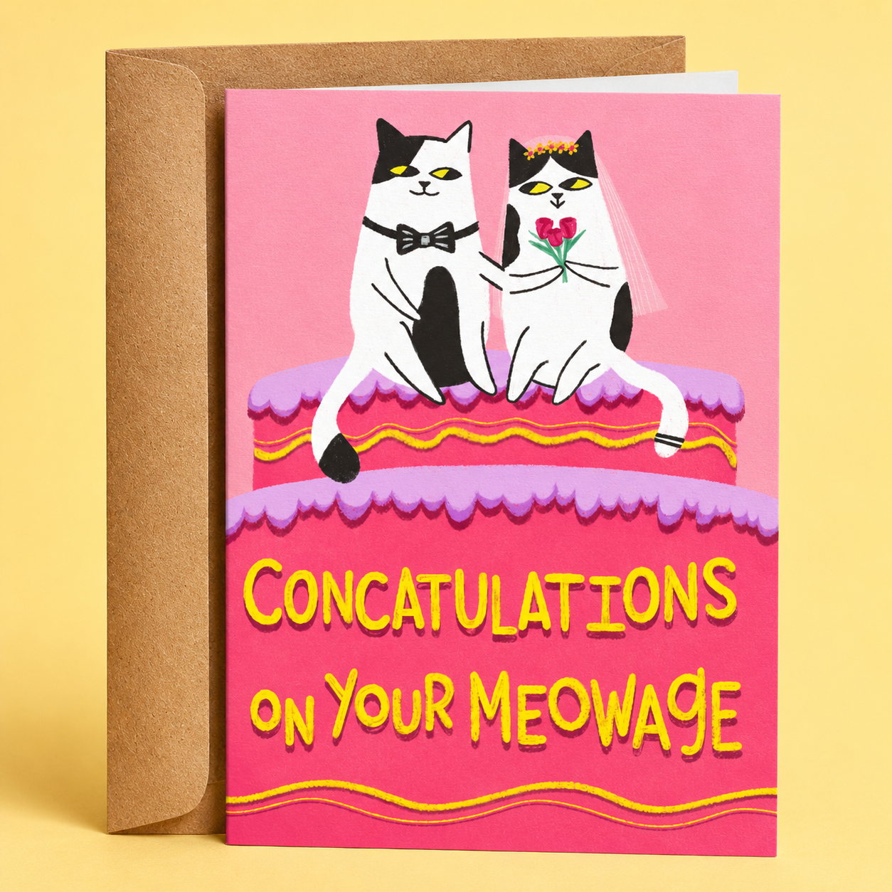Sleazy Greetings funny wedding congratulations card featuring two tuxedo cats dressed as a bride and groom sitting on a pink wedding cake with the pun “Concatulations On Your Meowage,” paired with a kraft envelope.