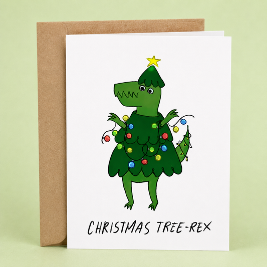 Sleazy Greetings funny Christmas greeting card featuring a dinosaur dressed as a Christmas tree and wrapped in colorful holiday lights with the pun “Christmas Tree-Rex,” paired with a kraft envelope.