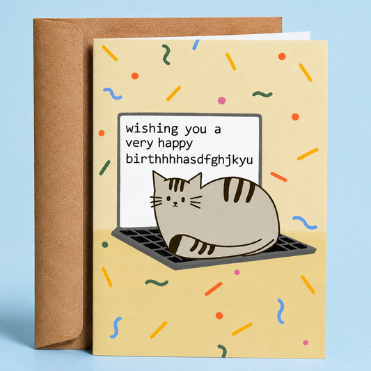 Sleazy Greetings funny birthday card featuring a cat sitting on a laptop keyboard causing a typo-filled birthday message that reads “Wishing you a very happy birthhhhasdfghjkyu” on a confetti background, paired with a kraft envelope.