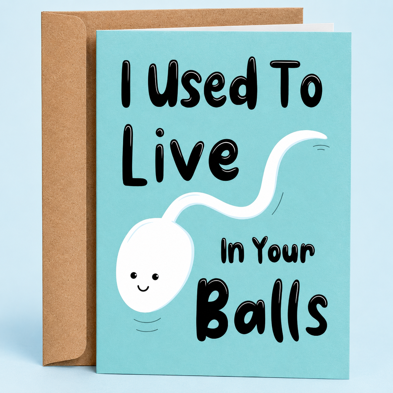 Sleazy Greetings funny Father’s Day greeting card featuring a cute smiling sperm illustration on a teal blue background with the joke “I Used To Live In Your Balls,” paired with a kraft envelope.