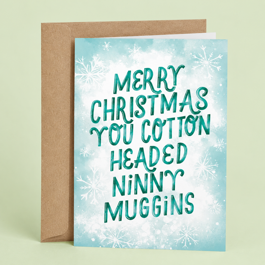 Sleazy Greetings funny Christmas card featuring “Merry Christmas You Cotton Headed Ninny Muggins” humor inspired by a classic holiday movie quote, with festive snowflake artwork, whimsical winter typography, and playful seasonal comedy on premium matte cardstock with kraft envelope.