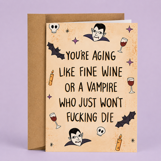 Sleazy Greetings funny Halloween birthday card featuring “You’re aging like fine wine or a vampire who just won’t fucking die” humor with vampire, bat, and wine illustration on premium matte cardstock with kraft envelope.