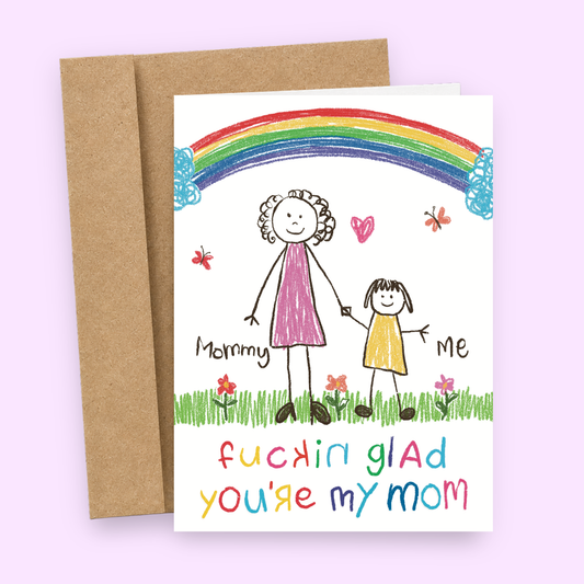 A humorous greeting card with a hand-drawn illustration of a mother and child with the text 'Fucking Glad You're My Mom'. The card has a colorful background with a rainbow and flowers, and comes with a kraft envelope.