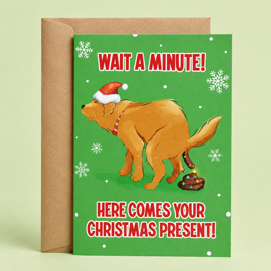 Sleazy Greetings funny Christmas card featuring the phrase ‘Wait A Minute! Here Comes Your Christmas Present!’ with a humorous dog illustration wearing a Santa hat while pooping a decorated holiday gift. Silly holiday greeting card with snowflake accents, bright green background, and a kraft envelope included.